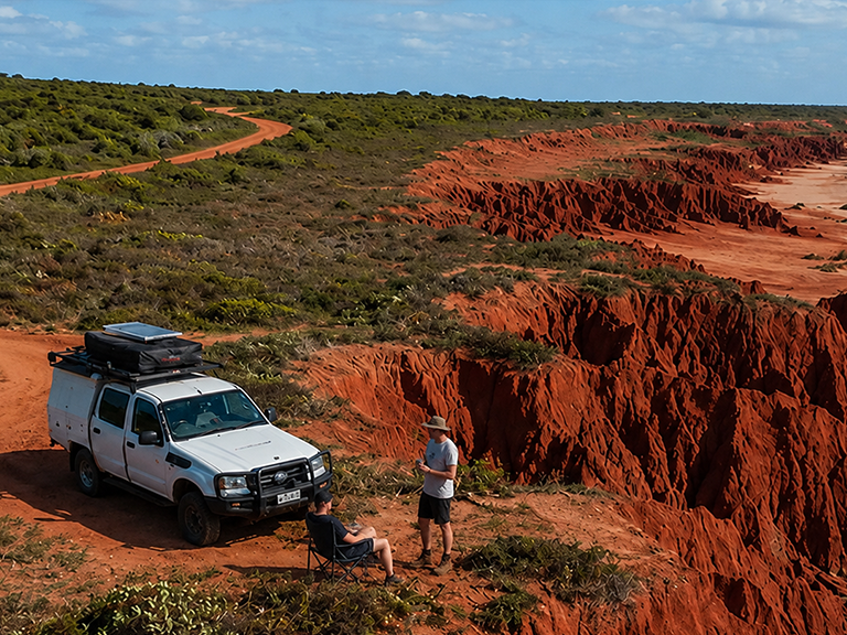 Travellers camping beside a 4WD camper at the red cliffs of James Price Point near Broome