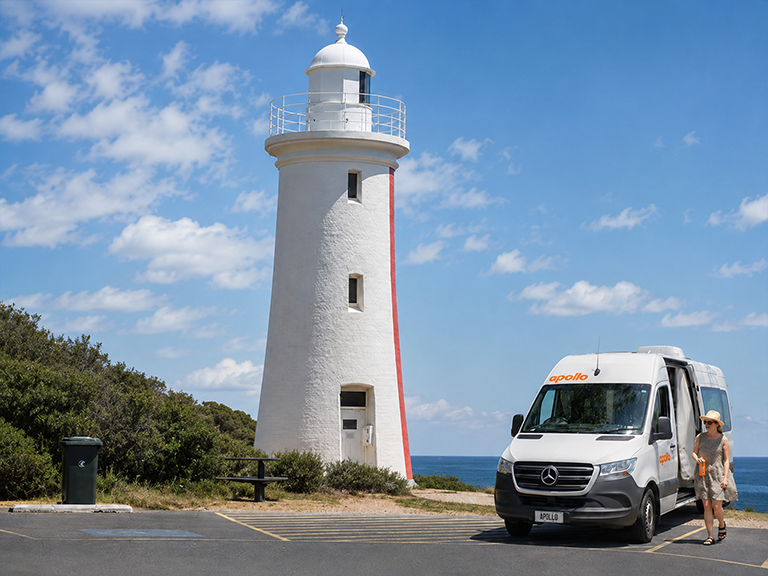 Traveller beside an Apollo campervan at Mersey Bluff Lighthouse in Devonport