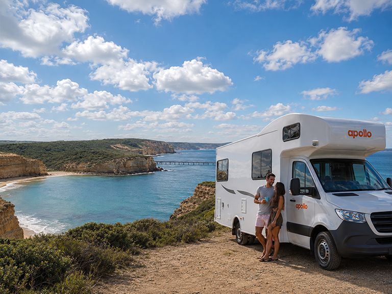 Couple beside an Apollo motorhome rental overlooking the Fleurieu Peninsula coast near Adelaide
