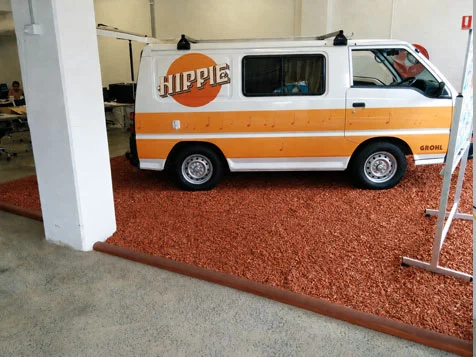 Hippie low top campervan rental inside shop surrounded by bark