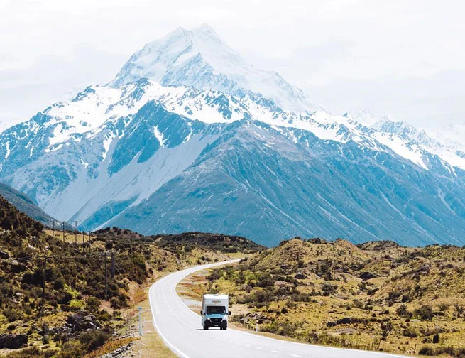 Mighty Big 6 motorhome driving through the snow-capped mountains of New Zealand’s South Island