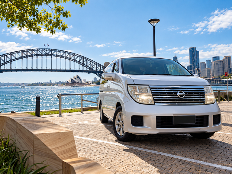 Johnny Feel Good campervan hire vehicle overlooking Sydney Harbour with the Harbour Bridge and Opera House in the background