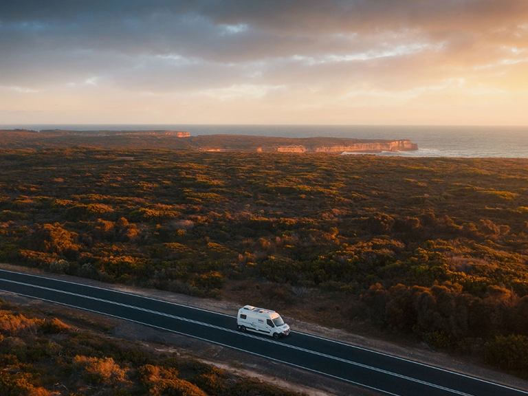 Motorhome hire vehicle travelling along Cape Nelson Road near the coastal cliffs of Portland, Victoria