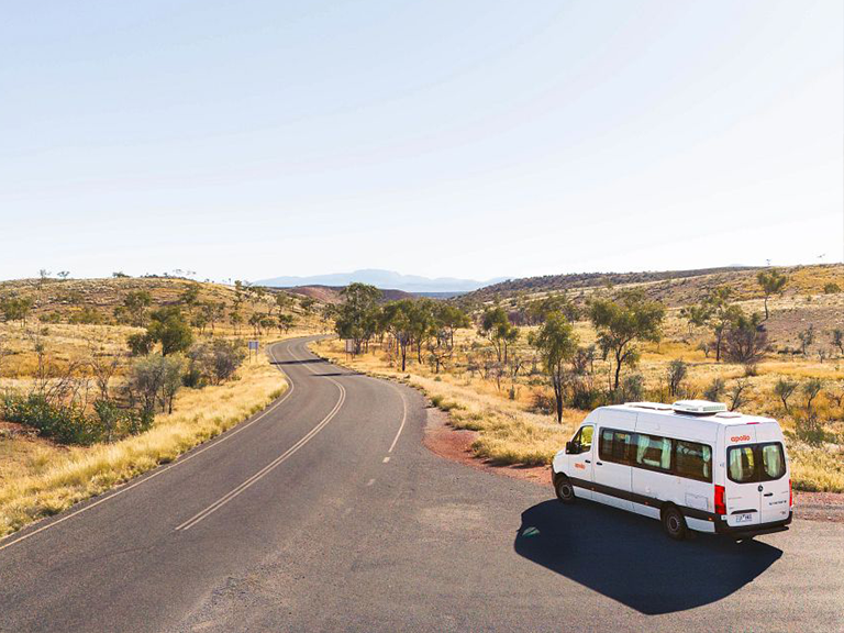Apollo campervan rental on a road through Tjoritja West MacDonnell National Park in the Northern Territory