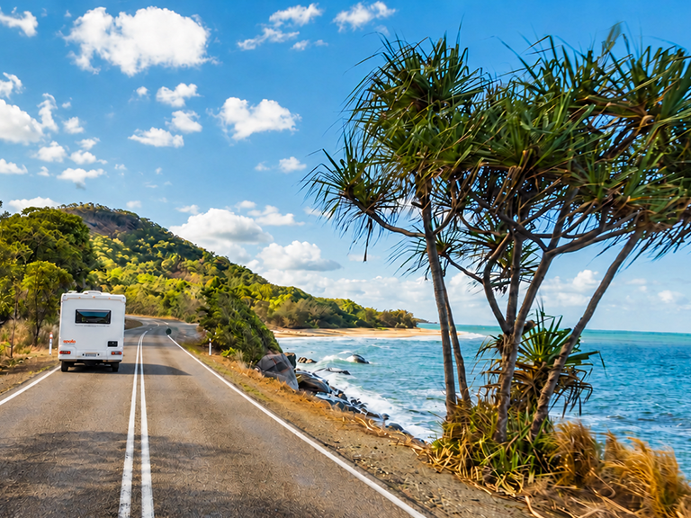 Apollo motorhome rental driving beside Boathaven Beach in Airlie Beach, Queensland